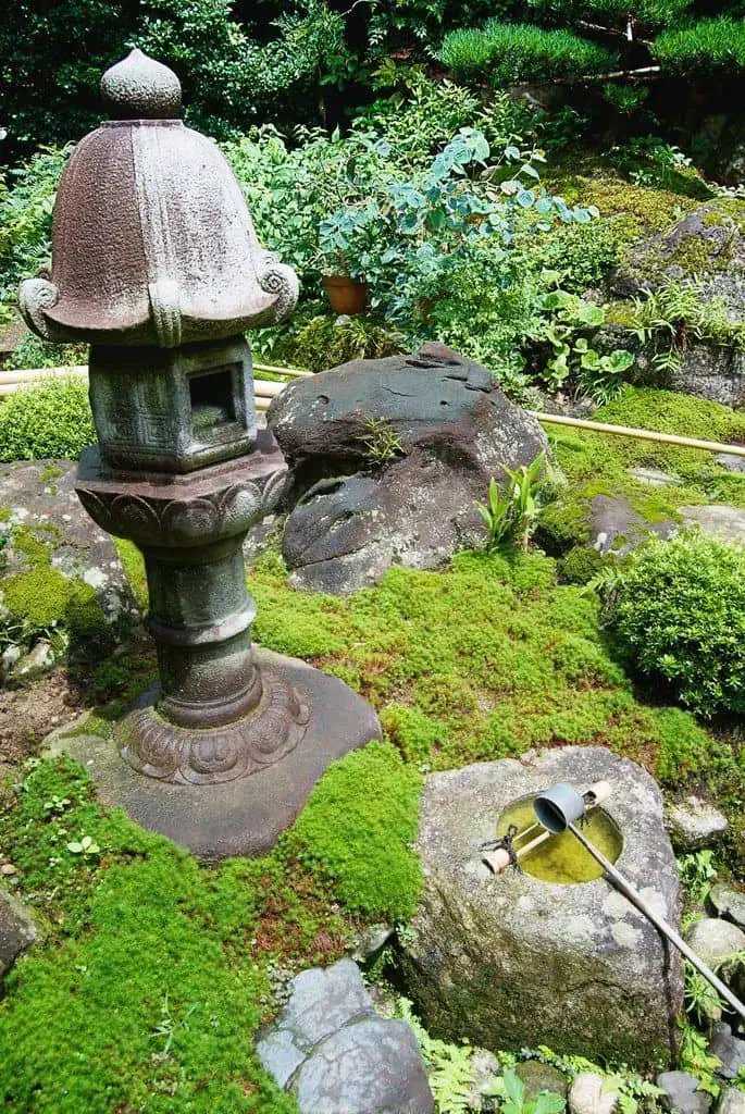 Linterna de piedra y cuenca en un jardín japonés Kyoto.